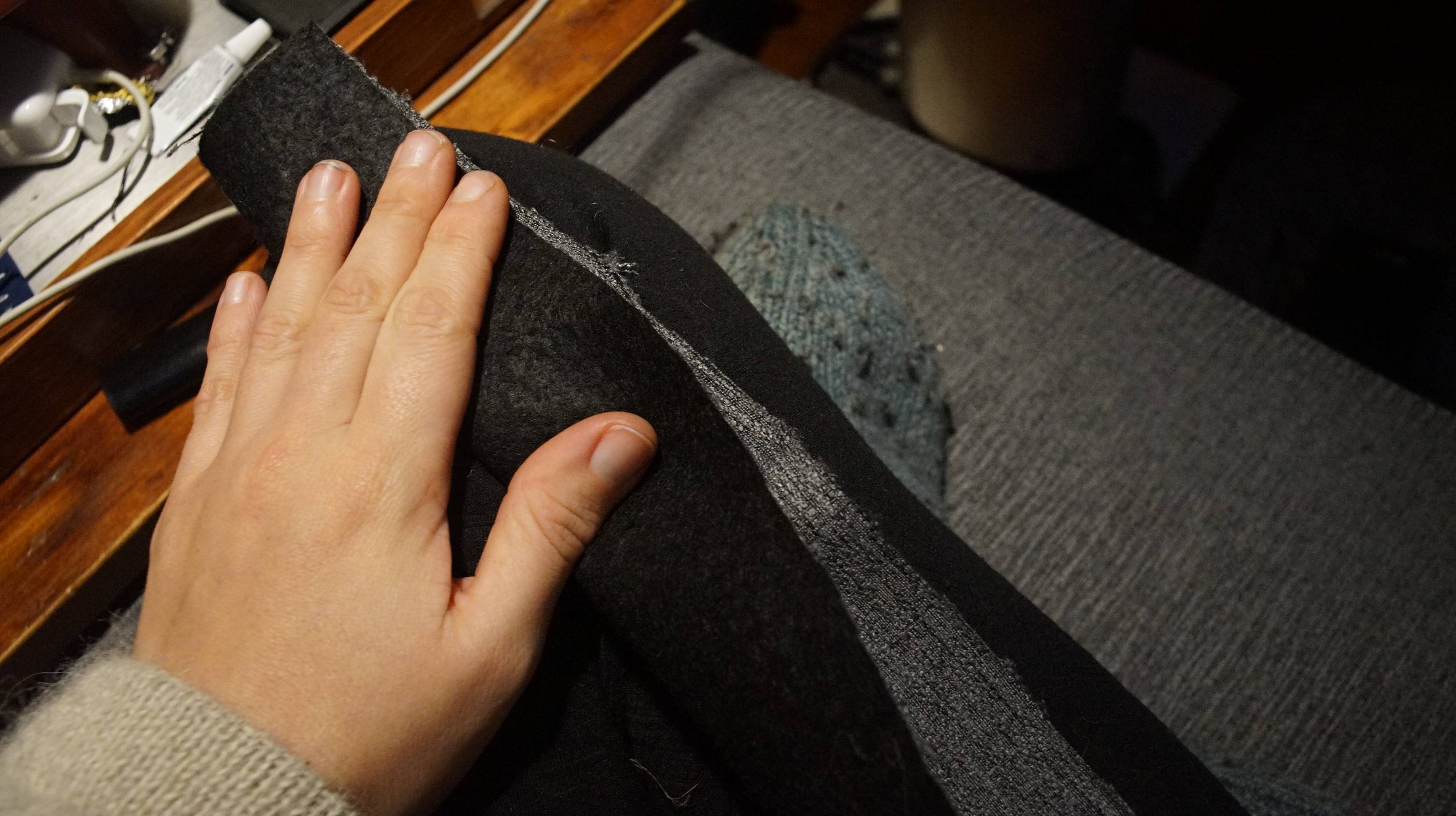 a hand folds the strip of fabric in half with the outsides facing inside