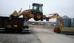 backloader lifting itself onto a railroad car