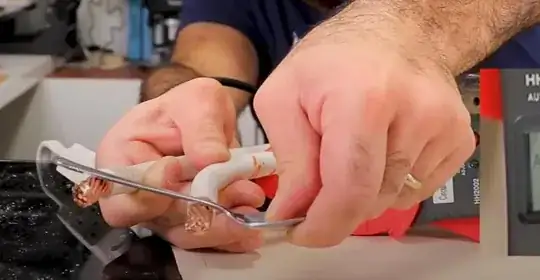 Mehdi holding a spoon between the two ends of the primary