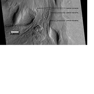 Material Flowing through a crater rim, as seen by HiRISE, under the HiWish program.  Lateral moraines are labeled.