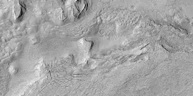 Surface breaking up, as seen by HiRISE under HiWish program.  Near the top the surface is eroding into brain terrain.