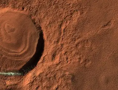 Close, color view of layered feature in crater, as seen by HiRISE under HiWish program. Different colors are due to different minerals.