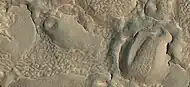 Close view of hollows formed when ice left the ground by sublimation. The ridges were formed when hollows that were next to each other grew in size.
