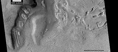 Dipping layers, as seen by HiRISE under HiWish program. Also, Ribbed Upper plains material is visible in the upper right of the picture.  It is forming from the upper plains unit, and in turn is being eroded into brain terrain.