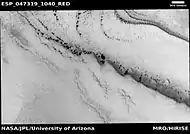 Wide view of spring defrosting.  The dark spots are where the ice has disappeared, thus revealing the dark surface beneath the ice.  Picture taken with HiRISE under HiWish program.