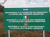 Sign in San Francisco, Córdoba, Argentina; unusually, the Spanish language is indicated by an Argentine flag, while below it is Italian and Piedmontese text with the flags of Italy and Flag of Piedmont.