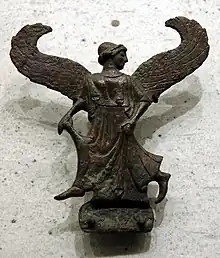 A statue of a woman with wings and a peplum draped around her